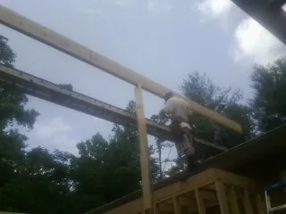 Carpenter setting a ridge beam over a new addition frame — Ice Dam Removal by Roofing Brothers in Kewaskum