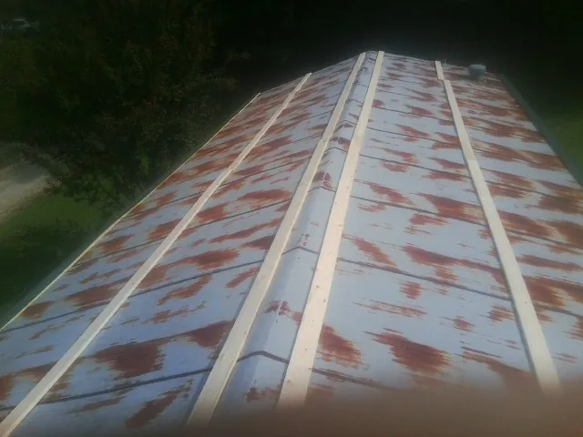 Rusted metal roof panels with new wood purlins before replacement — Storm Damage Roof Repair in Kewaskum by Roofing Brothers