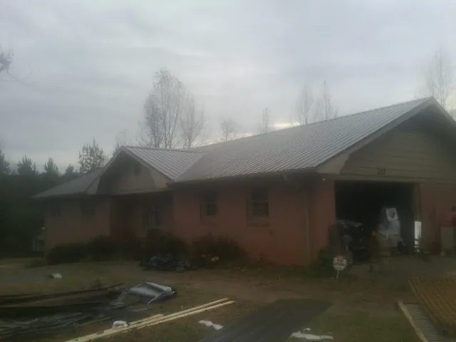 Gray metal roof on a stucco house with an attached garage in Kewaskum