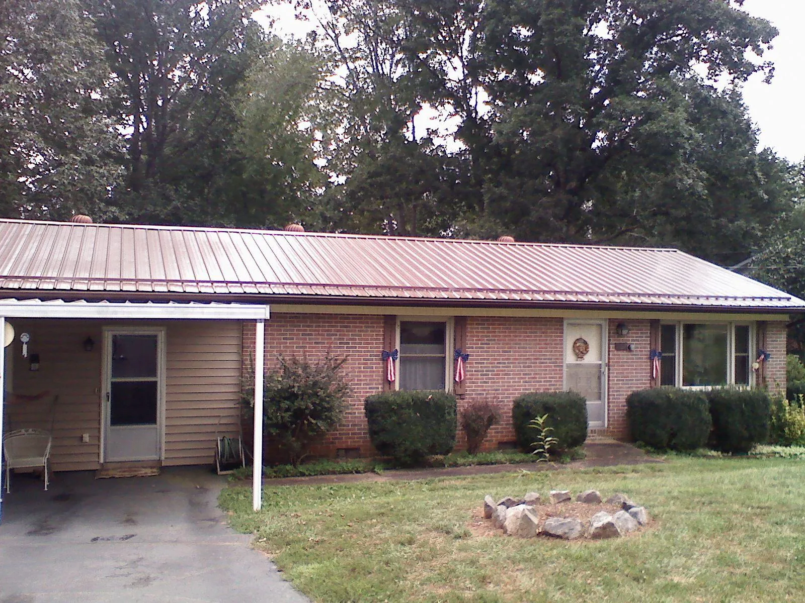 Bronze metal roof and carport on a brick ranch home — Roof Repair work by our crew in Kewaskum